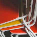 yellow and orange stacked school chairs